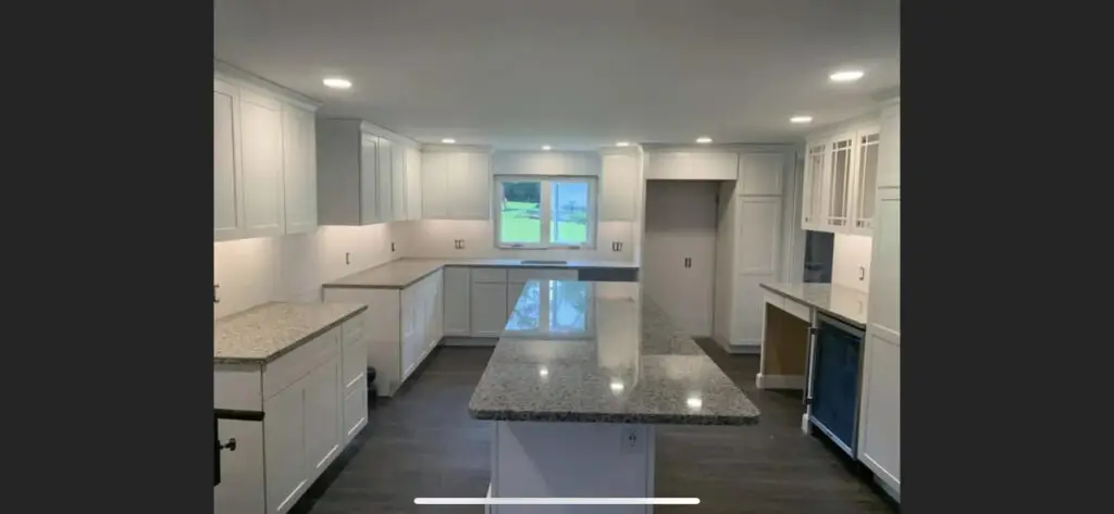Modern kitchen renovation featuring white cabinetry, granite countertops, and ample lighting, illustrating quality remodeling services in Southern New Hampshire.