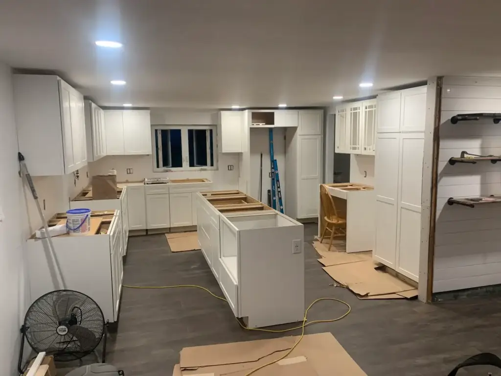 Kitchen renovation in progress, featuring white cabinetry installation, open layout, and construction materials, illustrating Next Step Property Services' handyman expertise in home improvement projects in Southern New Hampshire.